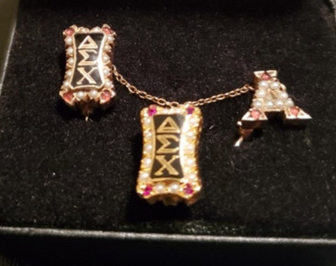 1920’s vertical, crown-set badge w/garnets and pearls